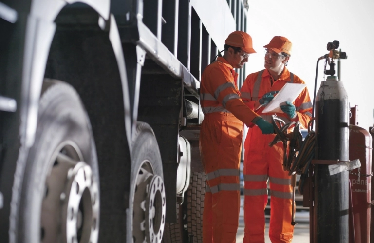 mężczyźni w&nbsp;pomarańczowych kombinezonach